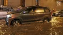 Kendaraan menerobos banjir di terowongan (underpass) Cawang menuju Halim Perdanakusuma, Jalan MT Haryono, Jakarta, Selasa (12/12). Hujan deras yang mengguyur sebagian Jakarta mengakibatkan banjir di kawasan ini. (Liputan6.com/Herman Zakharia)