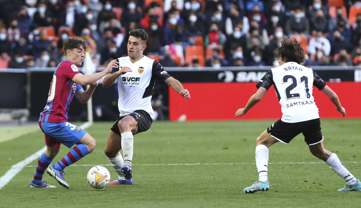 Gelandang Barcelona, Gavi mengontrol bola dari kawalan pemain Valencia, Hugo Duro pada pertandingan La Liga Spanyol di stadion Mestalla, Spanyol, Minggu (20/2/2022). Barcelona menang atas Valencia 4-2. (AP Photo/Alberto Saiz)
