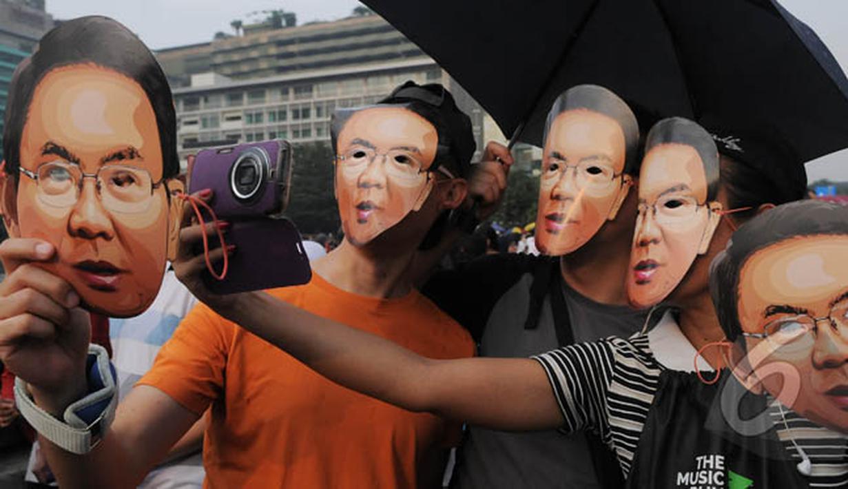 Sejumlah warga mengenakan topeng Ahok saat aksi 'Lawan Begal APBD' di Bundaran HI, Jakarta, Minggu (1/3/2015). Aksi mereka sebagai bentuk dukungan kepada Ahok yang ingin membongkar dana siluman di Pemprov DKI (Liputan6.com/Herman Zakharia)
