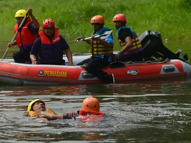 Anggota tim penyelamat berusaha menyelamatkan korban yang tenggelam pada lomba ketangkasan water rescue di Kanal Banjir Timur, Jakarta, Kamis (3/5). Perlombaan tersebut diikuti petugas pemadam kebakaran sewilayah Jakarta Timur. (Merdeka.com/Imam Buhori)