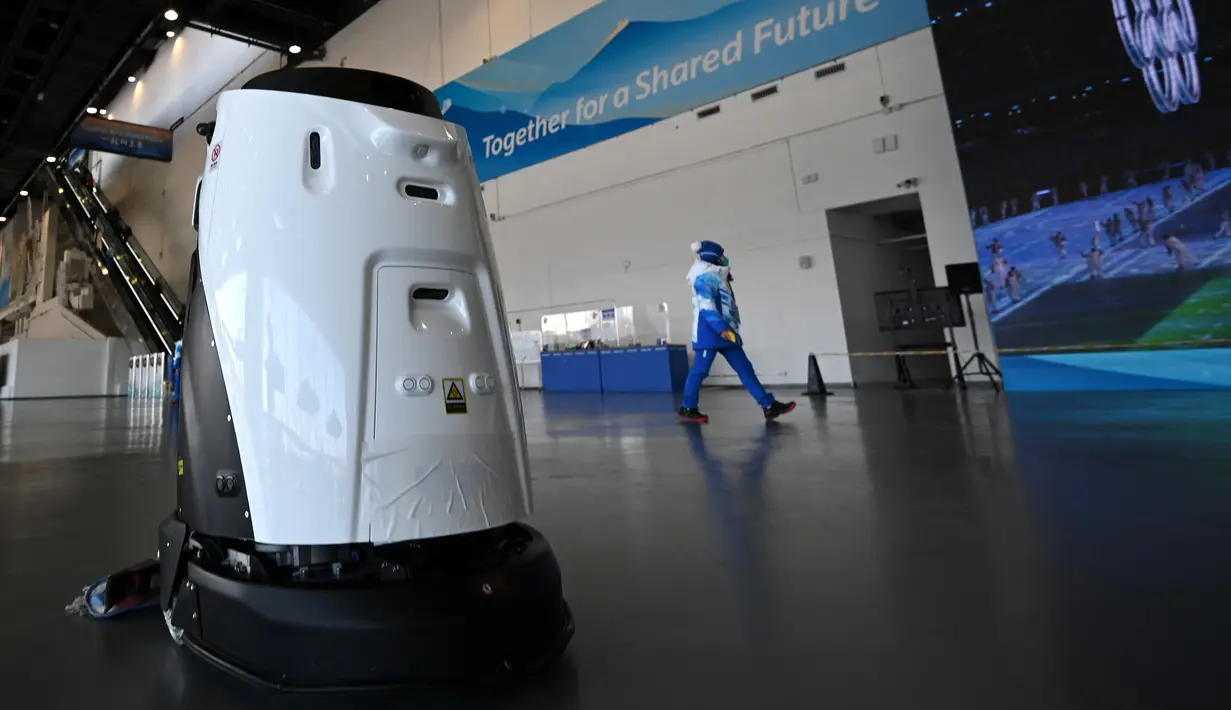 Robot membersihkan lantai Main Media Center selama Olimpiade Musim Dingin Beijing 2022 pada 5 Februari 2022. (AFP/Gabriel Bouys)