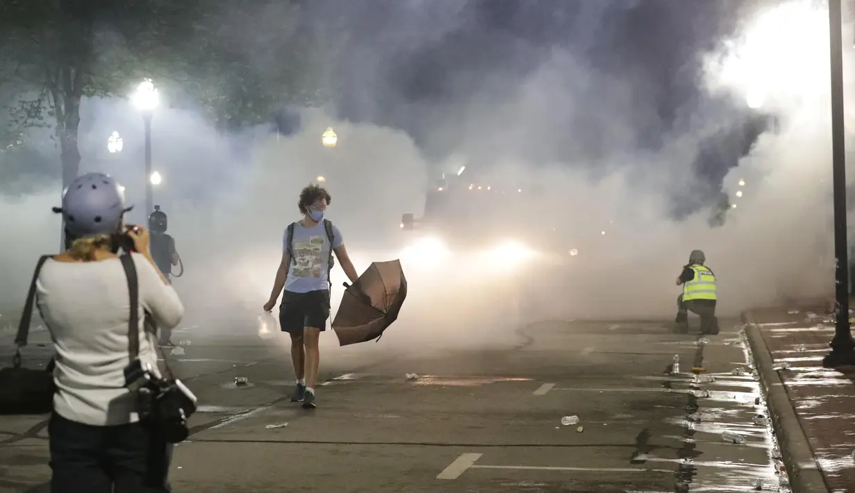 Pasukan Garda Nasional menembakkan gas air mata untuk membubarkan massa saat protes di Kenosha, Wisconsin, Amerika Serikat, Senin (24/8/2020). Protes dipicu oleh penembakan Jacob Blake oleh petugas polisi Kenosha sehari sebelumnya. (Rick Wood/Milwaukee Journal-Sentinel via AP)