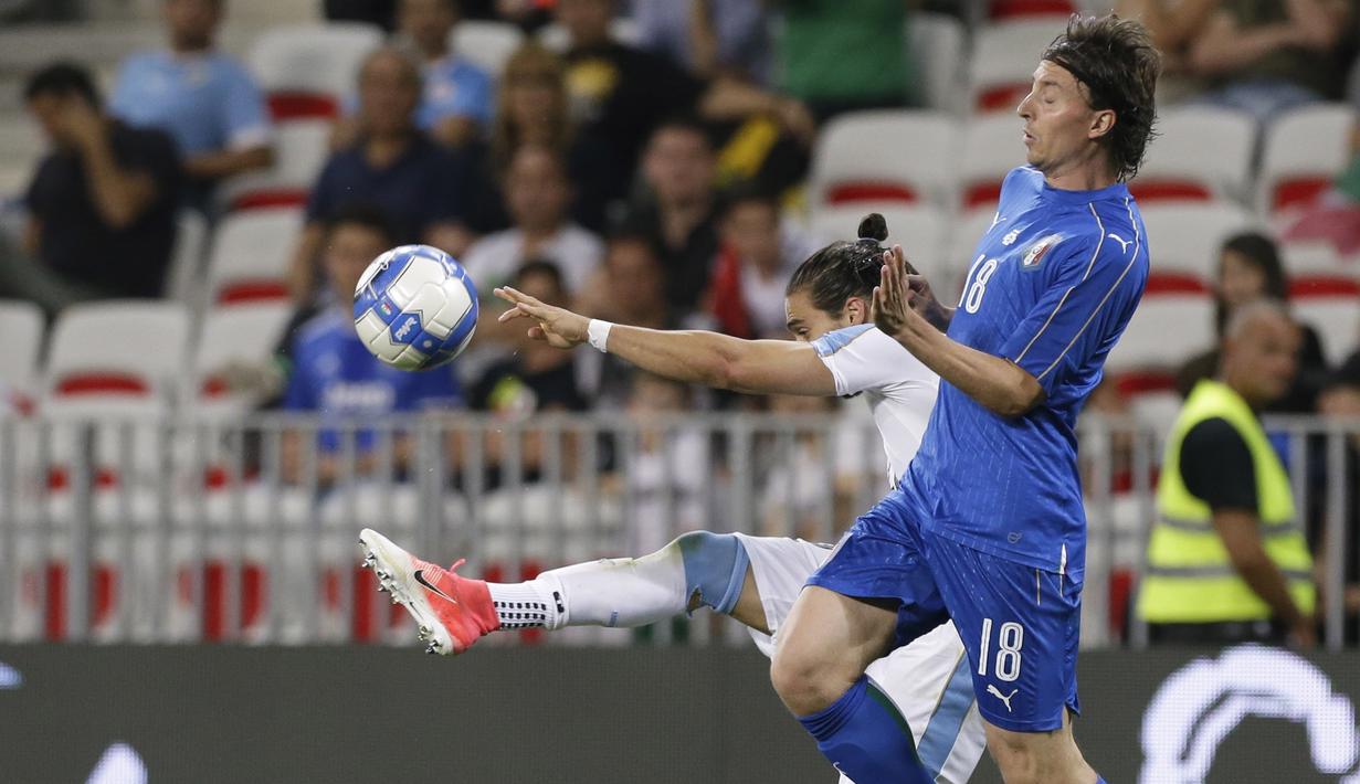 Pemain Uruguay, Martin Caceres menghalau bola dari kejaran pemain Italia, Riccardo Montolivo pada laga Persahabatan di Nice Allianz Riviera stadium, Prancis, (7/6/2017). (AP/Claude Paris)