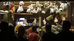 Keluarga Palestina membeli cokelat di sebuah toko yang dihiasi dengan boneka domba menjelang Hari Raya Idul Adha di kota Gaza pada Rabu (29/7/2020). (AP Photo/Hatem Moussa)