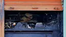 Seorang perwira polisi India mengecek restoran yang terbakar di Bangalore (8/1). Polisi mengatakan sebuah arus listrik pendek yang menyebabkan kebakaran di Kailash Bar & Restoran di pusat teknologi selatan Bangalore. (AFP Photo/Manjunath Kiran)