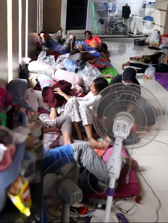 Aktivitas warga saat mengungsi di halaman Masjid Jami Al-Jihad, Perumahan Periuk Damai, Tangerang, Banten, Selasa (23/2/2021). Banjir setinggi 2,5 meter membuat warga harus mengungsi di tempat yang aman. (Liputan6.com/Angga Yuniar)