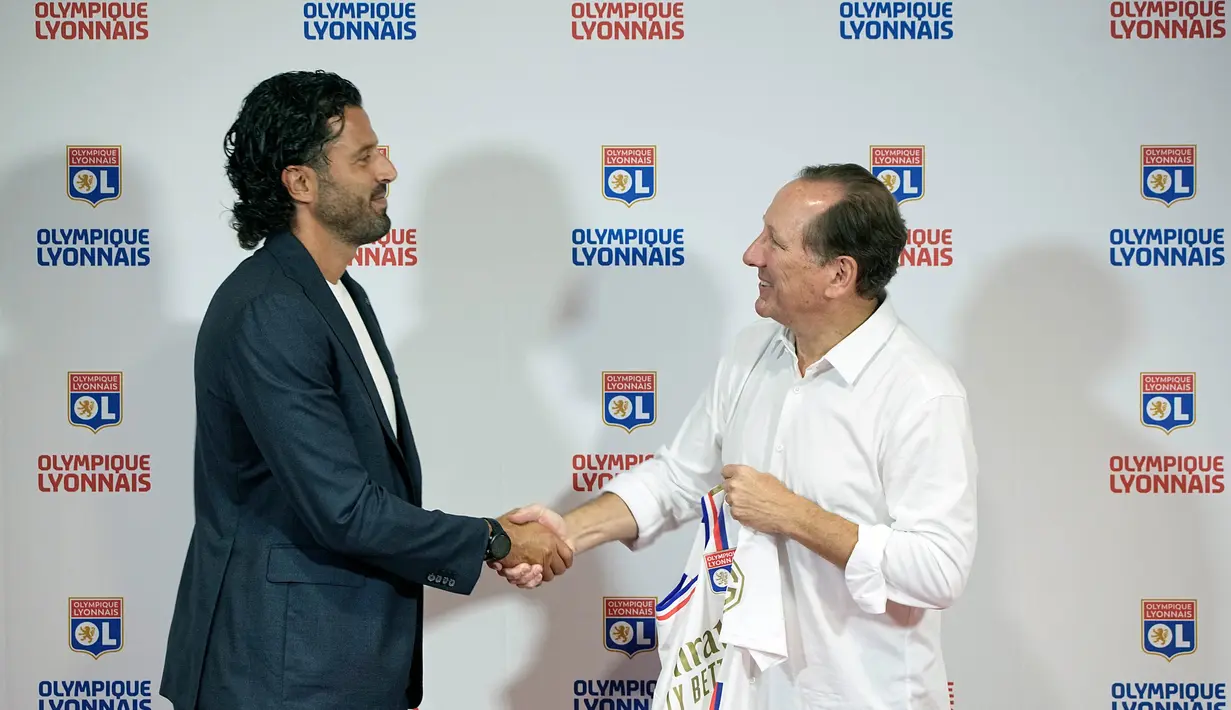 Presiden Lyon John Textor (kanan) berjabat tangan dengan Fabio Grosso usai diperkenalkan sebagai pelatih kepala baru Lyon di Stadion Groupama di Decines, dekat Lyon, Prancis tengah, Senin, 18 September 2023. (AP Photo/Laurent Cipriani)