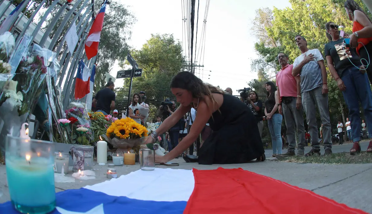 Seorang pendukung mantan Presiden Chile Sebastian Pinera meletakkan bunga di tugu peringatan untuk mengenangnya di luar rumahnya di Santiago pada tanggal 6 Februari 2024. (RAUL BRAVO/AFP)