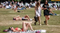 Sejumlah warga Inggris berjemur di atas rumput sambil menikmati sinar matahari di Green Park, London, Senin (25/6). Pada Juli 2018, suhu di ibu kota London tercatat 29.1 derajat Celcius dan diprediksi akan mencapai 30 derajat Celcius. (AFP/Tolga Akmen)