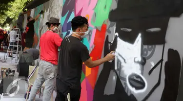 Seniman grafiti menyelesaikan karyanya selama festival Off The Wall di Kawasan Thamrin, Jakarta, Minggu (6/11). Gelaran ini memberikan perspektif baru terhadap seni urban sekaligus memperkenalkan para seniman Grafitti. (Liputan6.com/Gempur M. Surya)