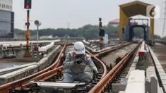Pekerja melakukan pengecekan arus listrik pada jalur Light Rail Transit (LRT) Jakarta di Depo LRT Jakarta Pegangsaan Dua, Jakarta, Rabu (8/5/2024). (Liputan6.com/Angga Yuniar)
