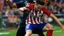 Gelandang Atletico Madrid, Saul Niguez (depan) mengontrol bola dari kawalan gelandang Muenchen, Douglas Costa di leg pertama liga champions di Vicente Calderon, Madrid, (28/4). Atletico menang atas Muenchen dengan skor 1-0. (Reuters/Sergio Perez)