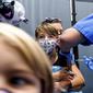 Finn Washburn (9) disuntik vaksin COVID-19 Pfizer-BioNTech saat adiknya, Piper Washburn (6) menunggu giliran saat vaksinasi anak 5 - 11 tahun di San Jose, California, Rabu (3/11/2021). Ini menjadi langkah perdana vaksinasi Covid-19 bagi anak kecil di Amerika Serikat. (AP Photo Noah Berger)