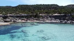 Pemandangan udara memperlihatkan pengunjung menikmati Semenanjung Akamas di sepanjang pantai barat Siprus (31/5/2020). Sampai tahun 2000, semenanjung itu digunakan oleh Angkatan Darat Inggris dan Angkatan Laut untuk latihan militer dan sebagai jarak tembak. (AFP Photo/Etienne Torbey)