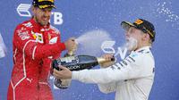 Pebalap Ferrari, Sebastian Vettel (kiri), tetap memuncaki klasemen F1 2017 meski kalah cepat dari Valtteri Bottas pada balapan GP Rusia di Sirkuit Sochi, Minggu (30/4/2017). (EPA/Valdrin Xhemaj)