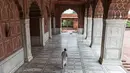 Pengurus berjalan seusai menempelkan stiker jaga jarak di lantai Masjid Jama yang dibuka kembali setelah pelonggaran lockdown di kawasan Kota Tua Delhi, Selasa (7/7/2020). India pada 6 Juli menjadi negara dengan jumlah virus corona tertinggi ketiga di dunia. (XAVIER GALIANA/AFP)