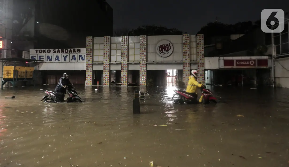 Warga mendorong motor saat terjebak banjir di Jalan Kemang Raya, Jakarta Selatan, Selasa (4/10/2022). Hujan yang mengguyur wilayah Ibu Kota Jakarta mengakibatkan banjir menggenangi kawasan Kemang, Jakarta. (Liputan6.com/Johan Tallo)
