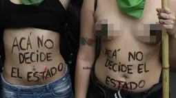 Wanita bertelanjang dada saat menggelar aksi di Buenos Aires, Argentina (29/9). Dekriminalisasi adalah penggolongan suatu perbuatan yang mulanya dianggap sebagai peristiwa pidana, tetapi kemudian dianggap sebagai perilaku biasa. (AFP Photo/Juan Mabromata)