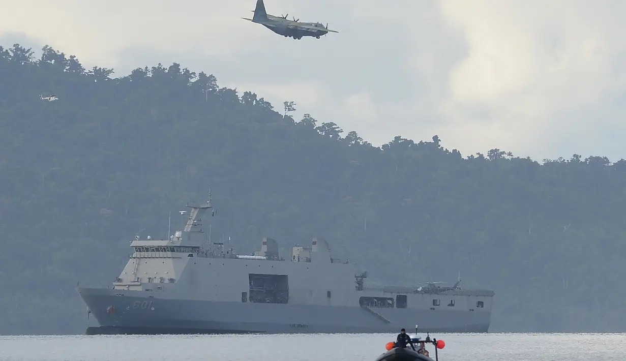 Pesawat kargo C-130 Filipina terbang di atas kapal angkatan laut Filipina BRP Tarlac terlihat saat latihan militer gabungan Filipina-AS tahunan di sebuah Pelabuhan laut di kota Casiguran, provinsi Aurora (15/5). (AFP Photo/Ted Aljibe)