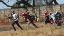 Pedagang Zimbabwe melarikan diri dari polisi setelah mereka diusir dari menjual barang dagangannya dari area yang tidak ditentukan karena pembatasan COVID-19 di Harare, Kamis (29/7/2021). (AP Photo/Tsvangirayi Mukwazhi)