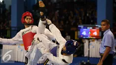 Taekwondoin Jawa Barat, Dinggo (kiri) melakukan tendangan ke arah pemain DIY, Okky Indera P saat laga final kelas -68kg PON XIX di Gymnasium UPI, Bandung, Senin (26/9/2016). Dinggo meraih emas setelah unggul 16-4. (Liputan6.com/Helmi Fithriansyah)