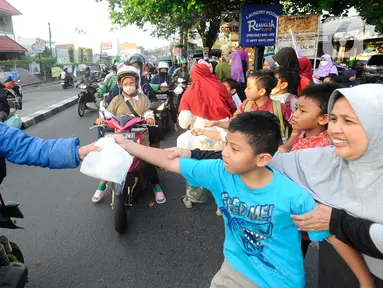 Anak-anak dari pengajian Salimah (Persaudaraan Muslima) membagikan takjil (makanan pembuka puasa) di kawasan Cinere, Depok, Jawa Barat, Senin (10/4/2022). (merdeka.com/Arie Basuki)