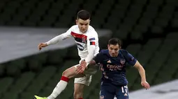 Bek Arsenal, Cedric Soares berebut bola di udara dengan bek Dundalk, Darragh Leahy dalam pertandingan Grup B Liga Europa 2020/2021 di Stadion Aviva, Jumat (11/12/2020) dini hari WIB. Arsenal menang 4-2 saat bertandang di markas wakil Irlandia, Dundalk. (Brian Lawless/PA via AP)