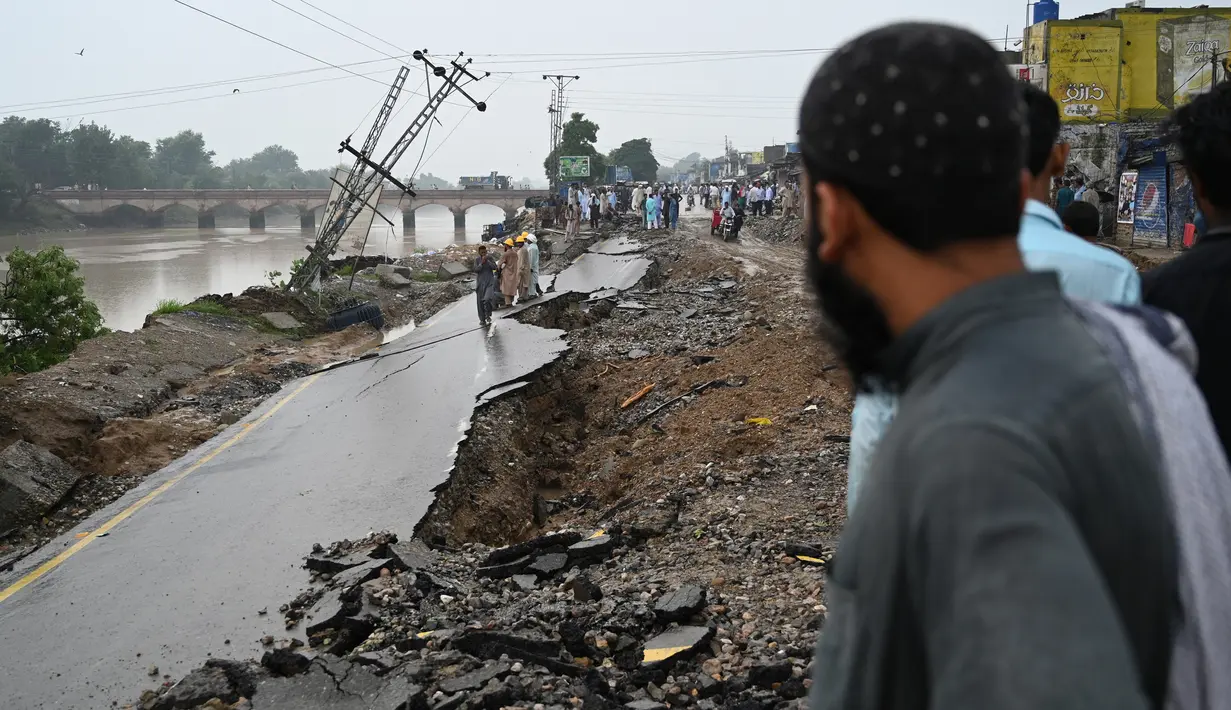 Seorang pria melintas di jalan yang rusak akibat gempa bumi yang melandi pinggiran Kota Mirpur, Pakistan, Rabu (25/9/2019). Menurut pihak berwenang, guncangan tersebut menewaskan sedikitnya 22 dan melukai lebih dari 300 warga.  (Photo by AAMIR QURESHI / AFP)