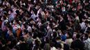 Pelancong yang mengenakan masker mengantre kereta di sebuah stasiun di Guangzhou di Provinsi Guangdong, China, Jumat (28/1/2022). Warga China melakukan perjalanan ke kampung halaman mereka untuk Tahun Baru Imlek, hari libur keluarga terbesar di negara itu. (Chinatopix via AP)
