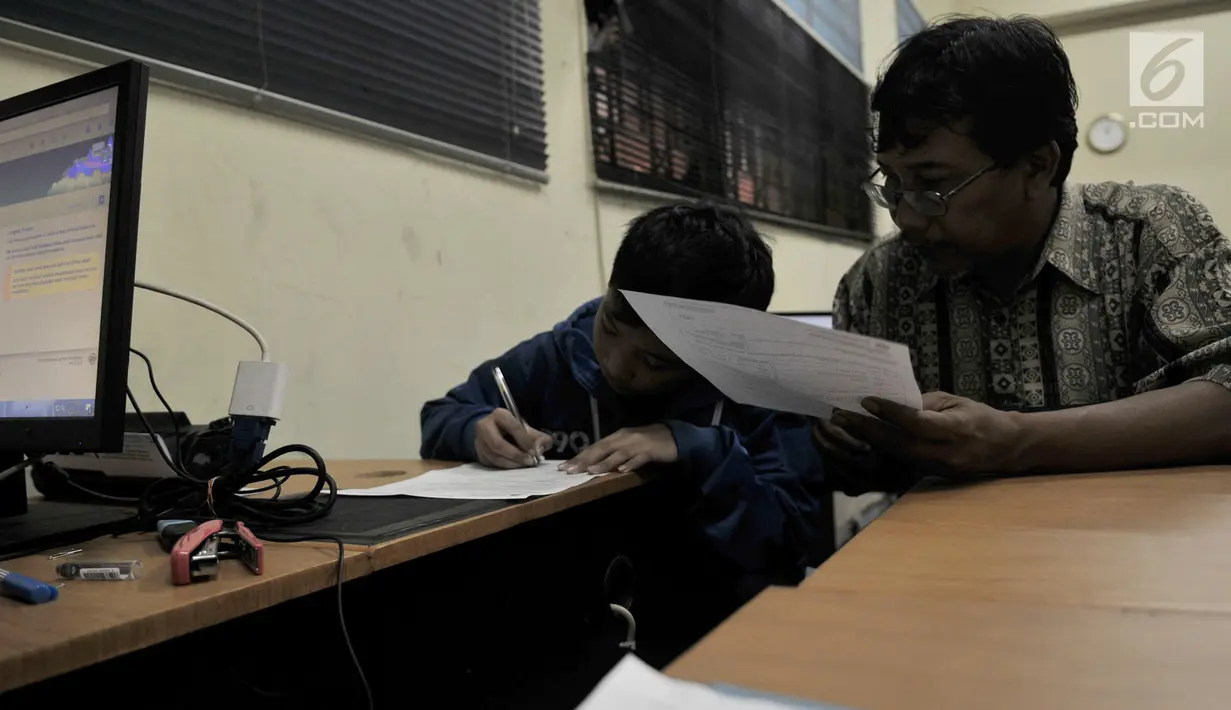 Orangtua membimbing anaknya saat mengisi identitas untuk pengambilan nomor token PPDB di SMPN 92, Jakarta, Senin (25/6). Nomor token ini merupakan syarat awal agar calon siswa dapat mendaftar PPDB secara online. (Merdeka.com/Iqbal S Nugroho)