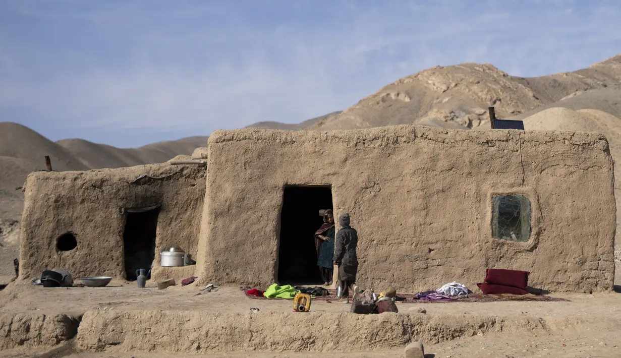 Cucu Haji Wali Jan (66) berdiri di pintu masuk rumahnya di desa Kamar Kalagh di luar Herat, Afghanistan, pada 26 November 2021. Kekeringan Afghanistan, yang terburuk dalam beberapa dekade, kini memasuki tahun kedua, diperburuk oleh perubahan iklim. (AP/Petros Giannakouris)
