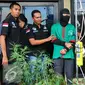 Tersangka DI (37) dihadirkan saat rilis di halaman Polres Jakarta Barat, Rabu (27/4).  Polres Metro Jakarta Barat amankan puluhan pot tanaman ganja serta puluhan gram paket ganja siap edar. (Liputan6.com/Yoppy Renato)