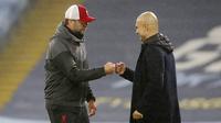 Pelatih Manchester City, Pep Guardiola dan pelatih Liverpool, Jurgen Klopp, saling menyapa pada laga Liga Inggris di Stadion Etihad, Minggu (8/11/2020). Kedua tim bermain imbang 1-1. (Martin Rickett/Pool via AP)