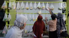 Warga sekitar perumahan Villa Pamulang mengambil paket sembako gratis bernama “Jumat Berkah” yang digantung di Tangerang Selatan, Jumat (28/8/2020). Setiap hari Jumat selama pandemi, warga perumahan itu mendonasikan sembako untuk warga sekitar yang terdampak COVID-19. (merdeka.com/Dwi Narwoko)