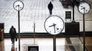 Para penumpang berjalan melalui Canary Wharf yang hampir sepi selama jam sibuk di London, Inggris, 12 Januari 2021. Inggris sedang menerapkan lockdown nasional ketiga untuk mengekang penyebaran virus corona COVID-19. (Victoria Jones/PA via AP)