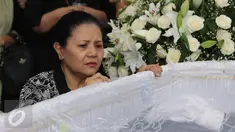 Kesedihan ibunda Mike Mohede, Amin Yudhayani, di samping peti jenazah Mike di rumah duka kawasan Bintaro, Tangsel, Senin (1/8). Mike Mohede mulai dikenal di dunia musik Indonesia setelah memenangi ajang pencarian bakat. (Liputan6.com/Herman Zakharia)