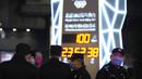 Petugas polisi berjaga-jaga di dekat jam hitung mundur 100 hari menuju pembukaan Olimpiade Musim Dingin Beijing 2022, di Beijing, China, Selasa (26/10/2021). Olimpiade Musim Dingin Beijing 2022 akan berlangsung 4 hingga 20 Februari. (AP Photo/Ng Han Guan)