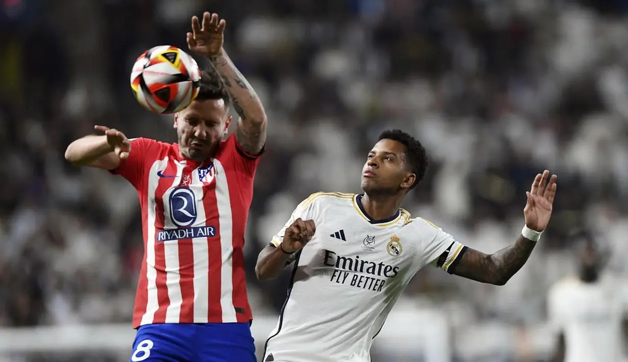 Pemain Real Madrid, Rodrygo, duel udara dengan pemain Atletico Madrid, Saul, pada laga semifinal Supercopa de Espana 2023/2024 yang digelar di Al-Awwal Park, Riyadh, Kamis (11/1/2024). (AP Photo)