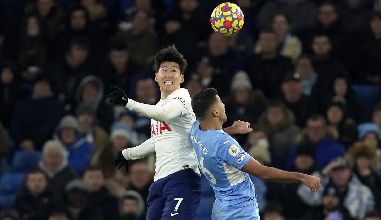 Penyerang Tottenham Hotspur Son Heung-min berebut bola dengan gelandang Manchester City Rodrigo pada pekan ke-26 Liga Inggris di Etihad stadium, Minggu (20/2/2022) dinihari WIB. Manchester City takluk 2-3 dari tim tamu, Tottenham Hotspur.  (AP Photo/Jon Super)