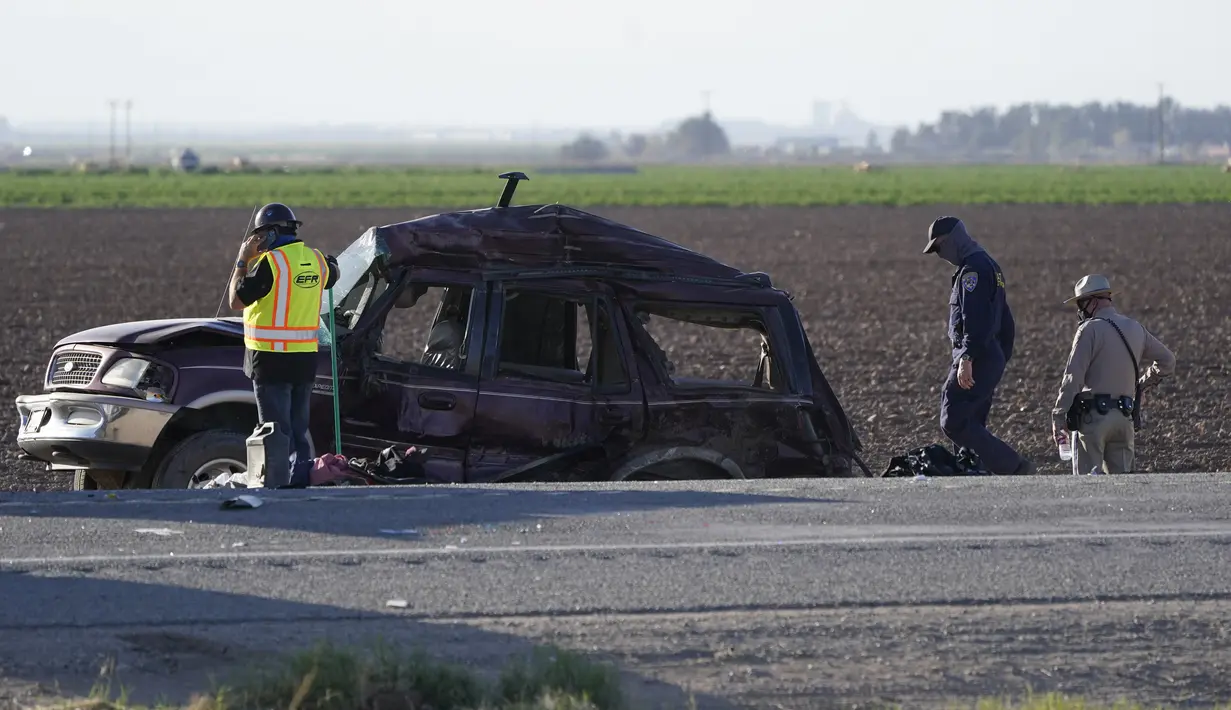 Petugas memilah bukti dan puing-puing di lokasi kecelakaan mematikan truk yang menabrak mobil SUV di Holtville, California (2/3/2021). Sebuah truk semi menabrak sebuah SUV yang membawa 25 orang di jalan raya California Selatan, menewaskan sedikitnya 13 orang. (AP Photo/Gregory Bull)