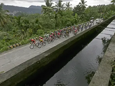 Pebalap melintasi jembatan air Indarung buatan Belanda pada Etape 6 Tour de Singkarak 2016 yang menempuh jarak 151,1 km dari Padang Pariaman menuju Sawahlunto, Kamis (11/8/2016). (Bola.com/Nicklas Hanoatubun)
