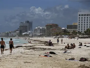 Wisatawan menikmati pantai sebelum kedatangan Badai Grace, di Cancun, Meksiko, Rabu (18/8/2021). Badai tropis Grace yang menguat menjadi badai pada 18 Agustus 2021 meluncur ke arah pantai Karibia, Meksiko dan mengancam akan membawa hujan lebat, banjir bandang dan gelombang besar. (AP/Marco Ugarte)