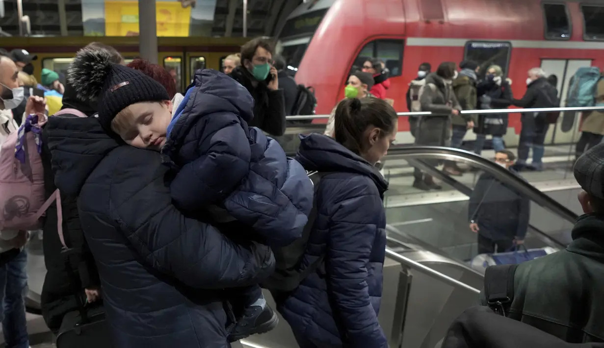 Seseorang menggendong bayi setelah kedatangan kereta bersama pengungsi Ukraina di stasiun utama di Berlin, Jerman, Selasa (1/3/2022). Menjelang malam, diperkirakan 300 orang tiba di Berlin dengan kereta api. Sejumlah relawan kemudian merawat orang-orang yang terdampar. (AP Photo/Michael Sohn)