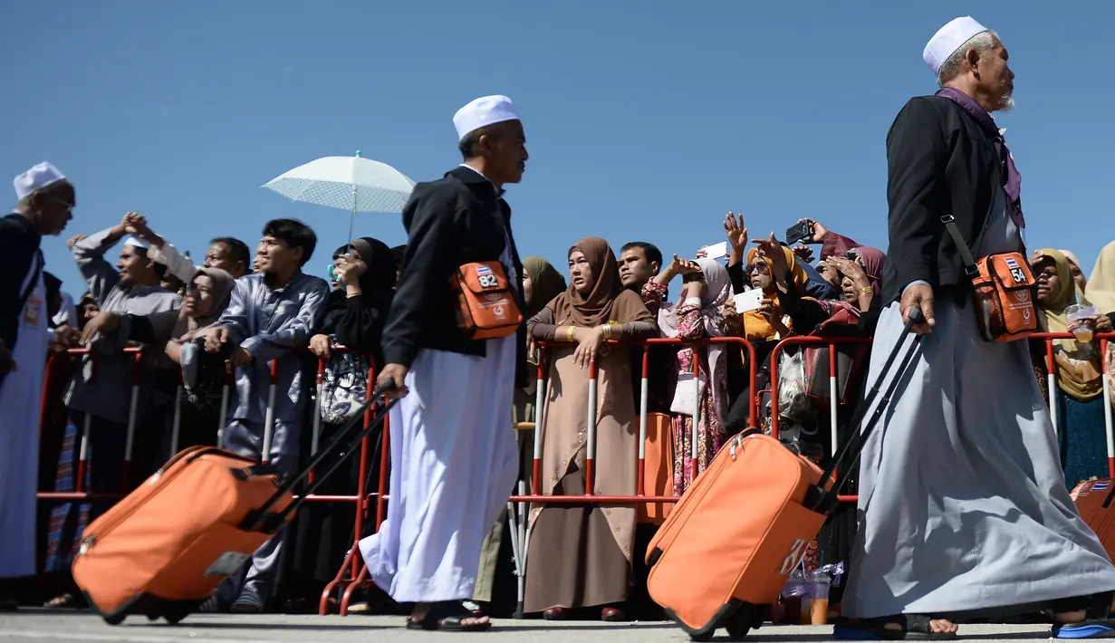 Jemaah calon haji berjalan menuju pesawat penerbangan khusus saat akan bertolak ke Tanah Suci Mekah di Bandara Provinsi Narathiwat, Thailand, Kamis (4/7/2019). Jutaan umat muslim dari penjuru dunia akan bertolak menuju Mekah untuk melangsungkan ibadah haji. (Madaree TOHLALA/AFP)