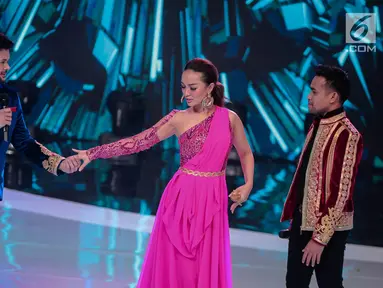 Pedangdut Fildan (kanan) melihat Ridho Rhoma (kiri) menggenggam tangan Zaskia Gotik (tengah) saat tampil dalam Indonesian Dangdut Awards 2018 di Jakarta, Jumat (12/10). Mereka membawakan lagu Koi Mil Gaya dan Tum Hi Ho. (Liputan6.com/Faizal Fanani)