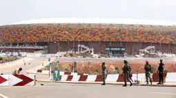 Sejumlah tentara Kamerun berpatroli di pintu masuk Stadion Olembe yang terletak di Yaounde, pada 7 Januari 2022. Stadion yang berkapasitas 60.000 penonton tersebut rencananya akan digunakan untuk venue pembukaan Piala Africa 2021. (AFP/Kenzo Tribouillard).