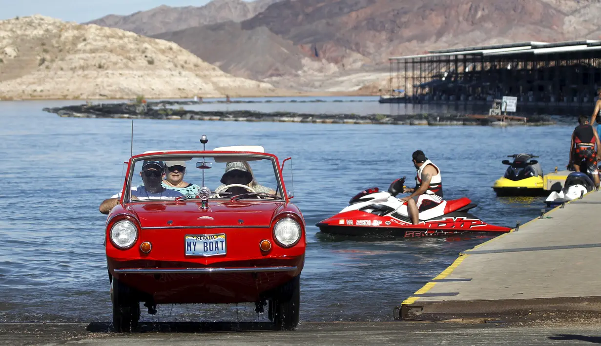 James Spear mengendarai mobil Amphicar 1964 usai berlayar berlayar pada festival Las Vegas Amphicar Swim di Danau Mead, Nevada, Jumat (9/10). (REUTERS/Steve Marcus)