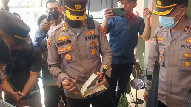 Kapolres Garut AKBP Wirdhanto Hadicaksono tengah mengecek keaslian surat dan dokumen kendaraan roda dua milik korban dalam penyerahan kendaraan hasil tangkapan curanmor. (Liputan6.com/Jayadi Supriadin)