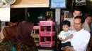Presiden Jokowi menggendong cucunya, Jan Ethes untuk melihat proses pembuatan soto di Solo, Jawa Tengah, Jumat (30/3). Kehadiran Jokowi membuat kedai semakin ramai. (Liputan6.com/Pool/Biro Pers Setpres)