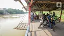 Warga menaiki perahu eretan di Sungai Cisadane, Neglasari, Kota Tangerang, Kamis (7/10/2021). Keberadaan jasa penyeberangan perahu eretan dengan tarif Rp 2.000 tersebut guna mempersingkat jarak tempuh dan waktu. (Liputan6.com/Angga Yuniar)